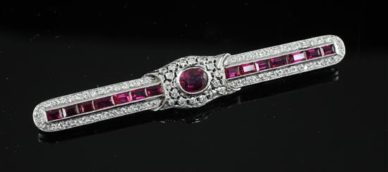 A mid 20th century white gold, ruby and diamond encrusted bar brooch, 61mm.